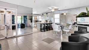 A modern hotel lobby with a reception desk, seating area, and a large mirror reflecting the space. - Ground Floor Condo | 2-Min Walk to Beach | Pools | Tennis | Shuffleboard | Sleeps 4 | WiFi! (Santa Rosa Beach)