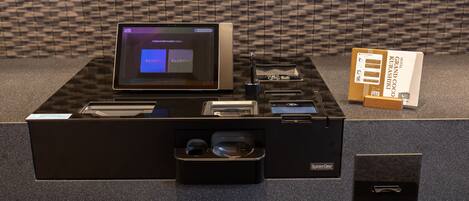 A hotel reception desk with a computer, a printer, and a small drawer unit.