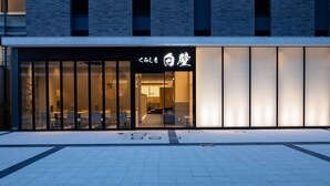 Un edificio moderno con fachada de vidrio y un letrero con caracteres japoneses.