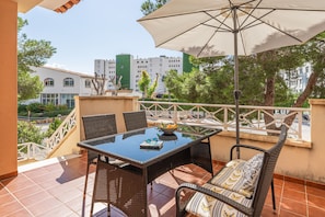 Une terrasse avec une table, des chaises et un parasol.
