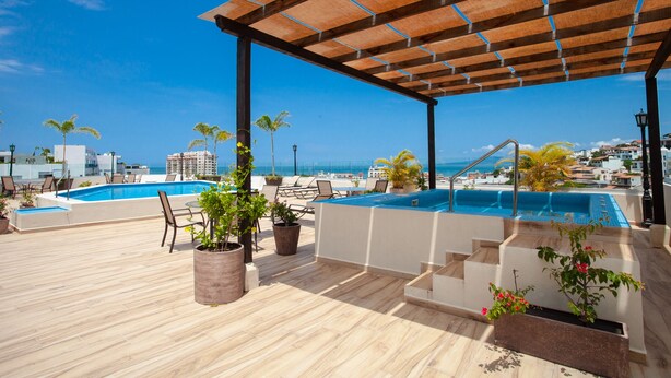 A rooftop pool area with a wooden pergola, lounge chairs, and potted plants. - 5 min to Los Muertos Beach in front of Cuale River located in Isla Cuale! 1BD Co (Puerto Vallarta)