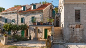 Un bâtiment en pierre doté d’un balcon et d’un escalier menant à l’entrée.