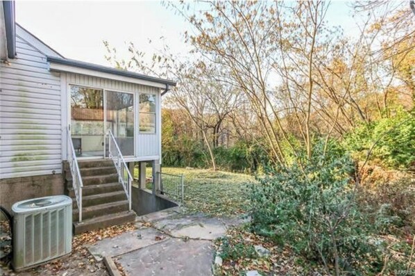 Stroll up to the charming single-story house, surrounded by a beautifully maintained garden with lush greenery.