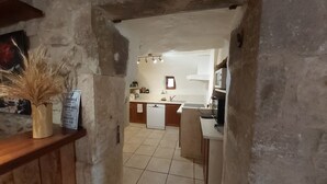 A narrow hallway leading to a kitchen with a tiled floor, a white countertop, and a microwave. - Mas DISTAISE, 5 bedrooms, 4 bathrooms, pool, billiards.  Vacations with family and friends (Grane)