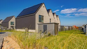 A modern residential building with a sloped roof, large windows, and a well-maintained lawn. - Stunning home in Büsum with sauna (Büsum)