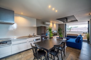 Enjoy meals and relaxation in this kitchen with a dining table, sofa, and large window.