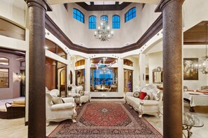 Un interior espacioso y elegantemente decorado, con techos altos, ventanas amplias y muebles clásicos.
