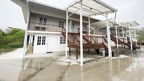 A two-story building with a covered balcony and a garage. - OYO Home 90329 Bridge House Homestay (Ranau)