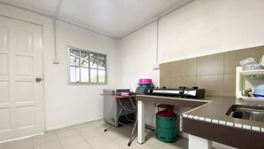A small kitchen with a gas stove, a sink, a window, and a door. - OYO Home 90329 Bridge House Homestay (Ranau)