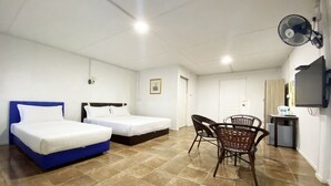 A hotel room with two beds, a dining area with chairs, a fan, a TV, and a small table with items on it. - OYO Home 90329 Bridge House Homestay (Ranau)