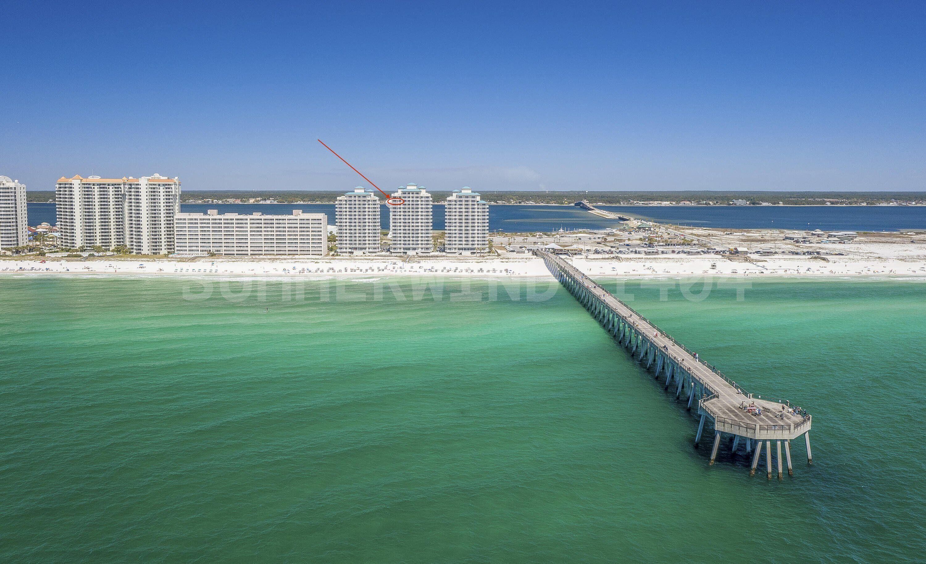 A coastal cityscape with a prominent pier extending into the water.