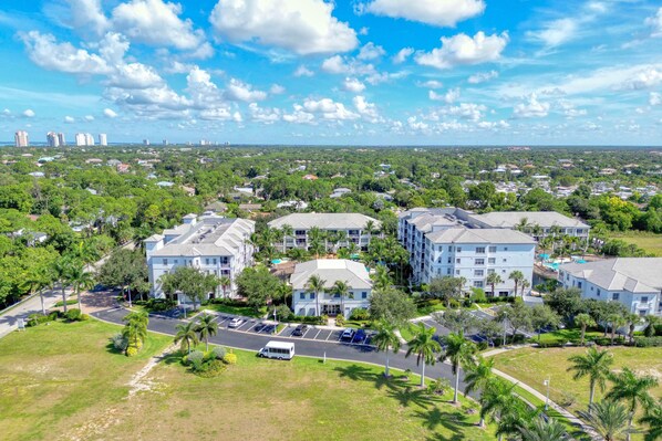 A residential area with multi-story buildings, parking lots, and green spaces. - Updated Modern Poolside Condo! (Bonita Springs)
