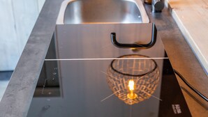 Une cuisine moderne équipée d’une cuisinière intégrée, d’un évier et d’une machine à café.