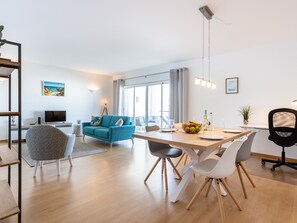 Relax in this stylish living space with a sofa, armchair, and dining table for a comfortable stay.