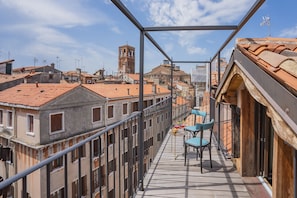 A balcony with a view of a cityscape, including buildings and a tower.