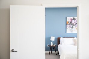Ein Hotelzimmer mit einem Bett, einem Nachttisch mit Lampe und einem Wandbild.