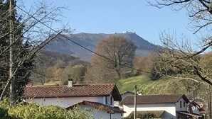Ländliche Landschaft mit Häusern und einer Erhebung im Hintergrund.