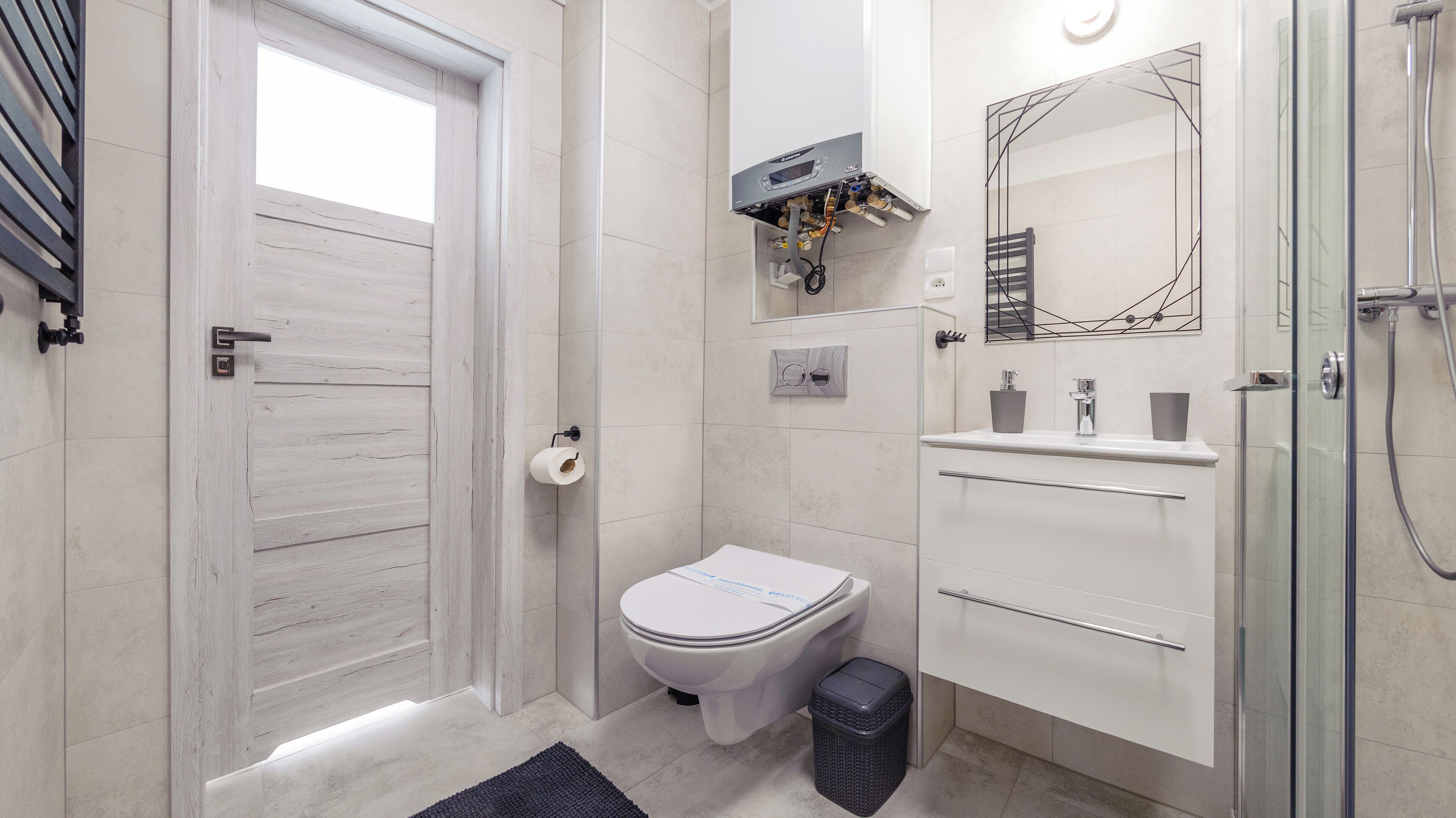A modern bathroom with a toilet, bidet, and shower.