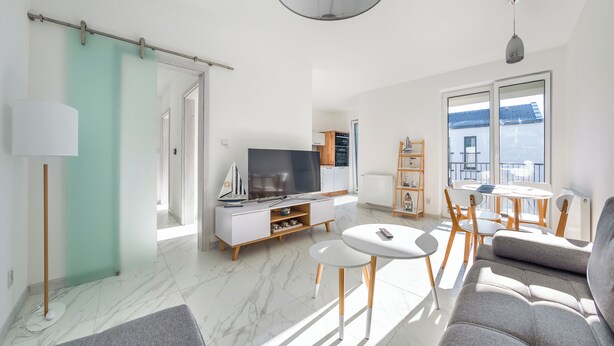 A modern living room with a TV, sofa, and dining area.