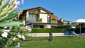Une maison moderne dotée d’un grand balcon, d’une piscine et d’une pelouse bien entretenue.