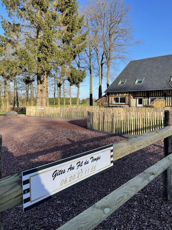 A stable with a sign indicating dates and a wooden fence.