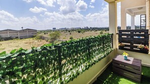 A balcony with a view of a dry landscape and distant buildings. - Hirwado Homes - QUIET/Secure/15 Mins to JKIA /SGR (Mlolongo)