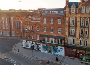 Una vista di una strada con un edificio con la scritta 'MARINERS BAR' e un altro edificio con il cartello 'GALLERY'.