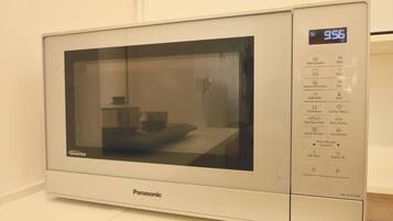 Un four à micro-ondes Panasonic doté d’un écran numérique affichant 9,56, d’un minuteur réglé sur 10 minutes et de diverses options de cuisson.