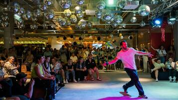 A dance performance in a venue with a high ceiling and disco balls.