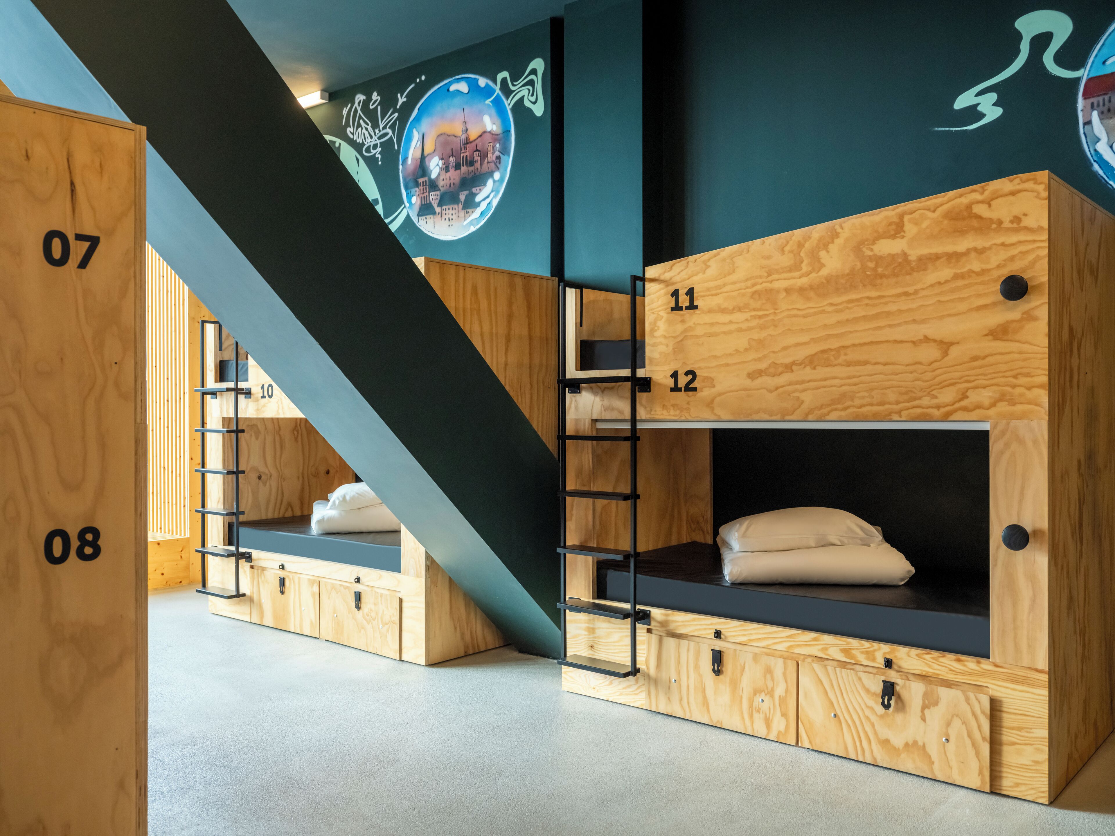 A modern room with bunk beds labeled 07 and 08, wooden cabinets, and a staircase.