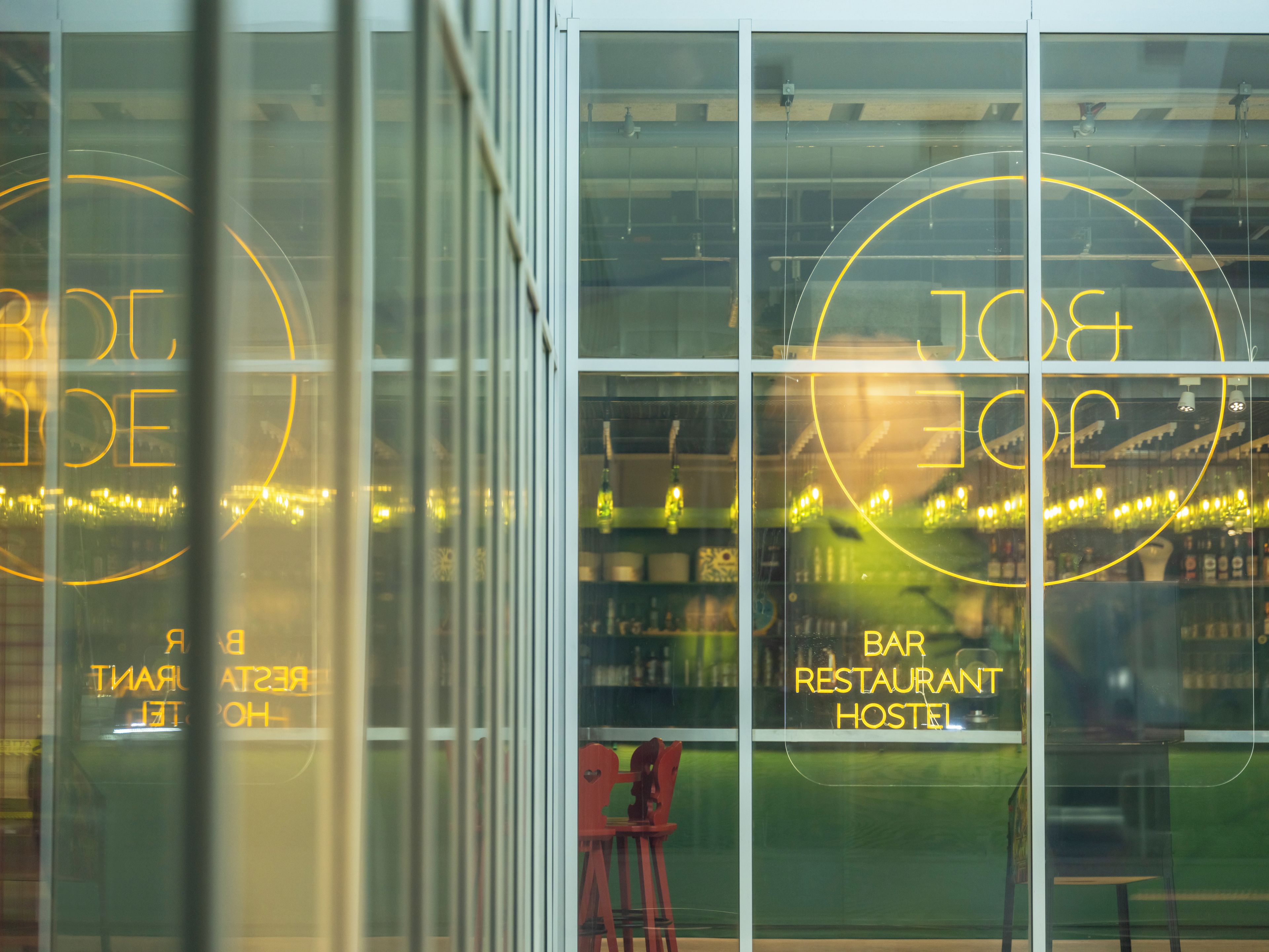 A bar, restaurant, and hostel with illuminated circular signs.