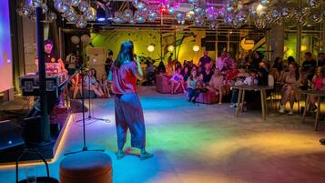 Una sala con un escenario, bolas de discoteca y una multitud de gente.