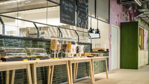 A self-service breakfast bar with various food options and a chalkboard menu. - JO&JOE Vienna - Hostel (Vienna)