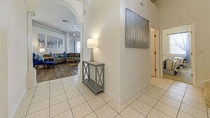 A spacious living area with a sofa set, a console table, and a painting on the wall.