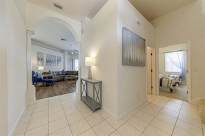 A spacious living area with a sofa set, a console table, and a painting on the wall.