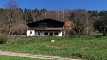 Situated in a lush landscape, this chalet-style building features a balcony with a view of the surrounding area.