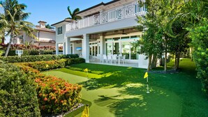 A modern two-story building with a covered patio area and a well-maintained lawn.