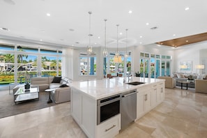A spacious kitchen with a large island, modern appliances, and ample natural light. - Modern Fort Lauderdale Waterfront Villa (Fort Lauderdale)