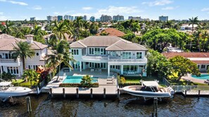 A large waterfront property with a swimming pool, docked boats, and a view of the city skyline. - Modern Fort Lauderdale Waterfront Villa (Fort Lauderdale)