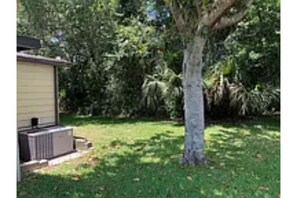 Enjoy a peaceful retreat in this single-story home surrounded by a lush lawn and trees.