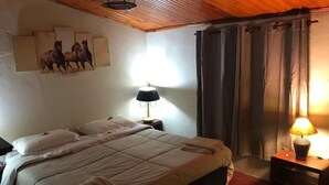 Ein Schlafzimmer mit einem großen Bett, zwei Nachttischen, einer Lampe und einem Bild an der Wand.