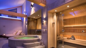 A modern spa with a hot tub, wooden benches, and a sauna area. - Honister Cottage - Luxury Cottages (Kendal)