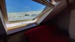 Una habitación con tragaluz que da a un paisaje nevado.