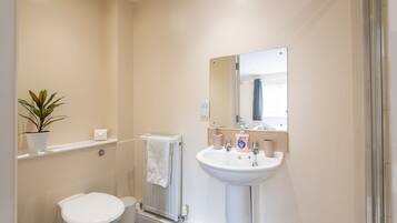 A bathroom with a toilet, sink, and a towel rack.