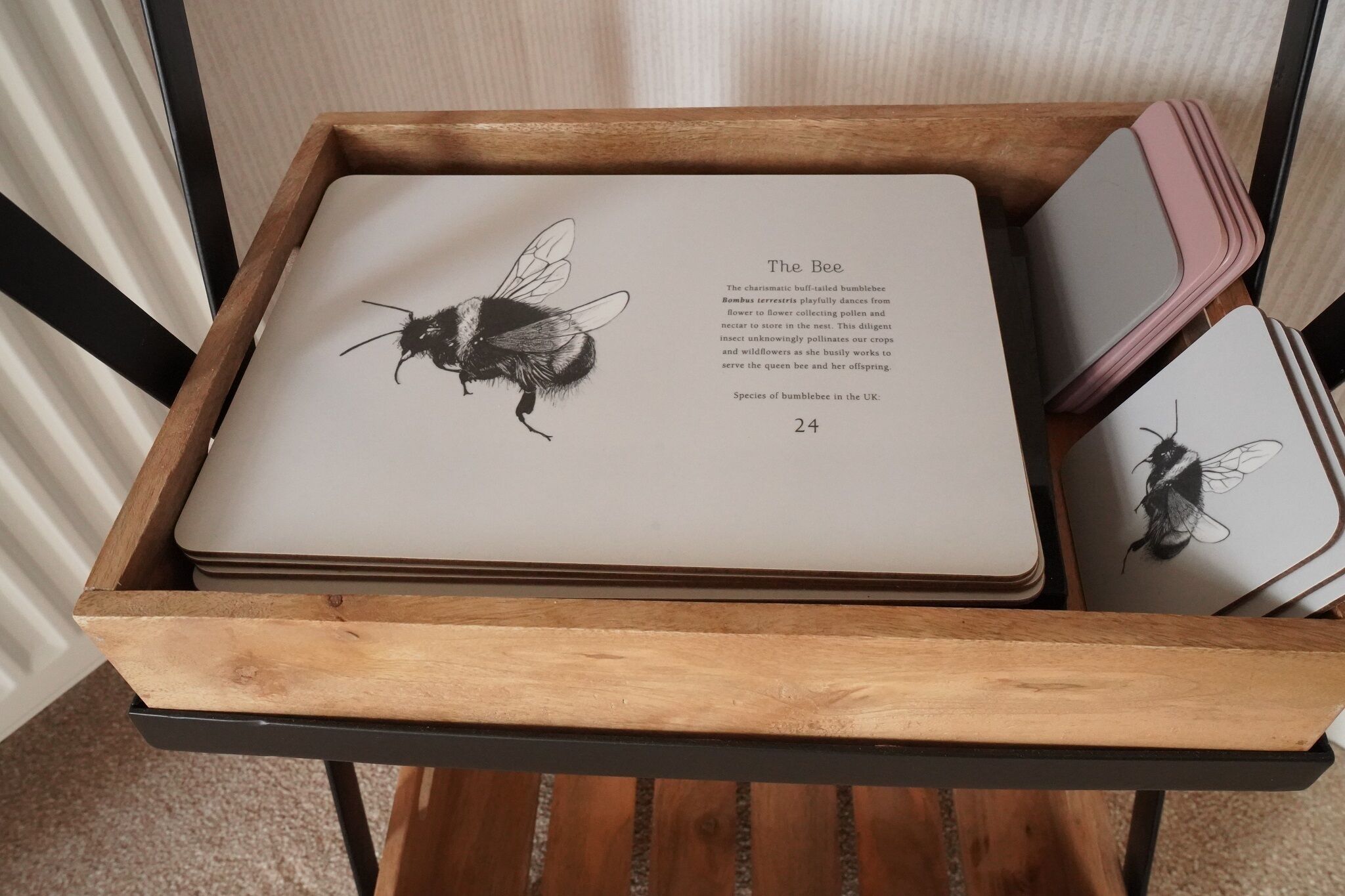 A wooden tray with a book and a stack of notebooks.