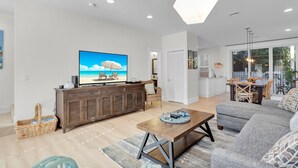 A modern living room with a flat-screen TV, a wooden coffee table, and a grey sofa. - ~Reel Paradise~Beautiful private townhouse in a small gated community. (Key West)