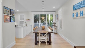 A spacious kitchen with a central island, white cabinetry, and a large window providing a view of the outdoors. - ~Reel Paradise~Beautiful private townhouse in a small gated community. (Key West)