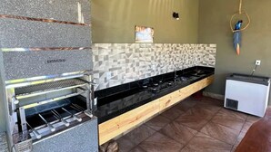 Una cocina con horno empotrado, salpicadero de azulejos y techo de madera.