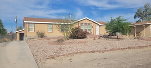 A residential house with a front porch, a driveway, and a landscaped front yard.