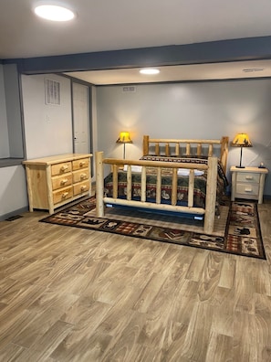 Cozy retreat with a central bed, nightstands, and a dresser, set against a light-colored backdrop.
